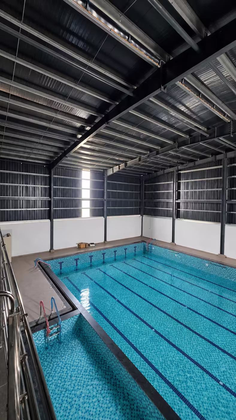 The indoor temperature-controlled lap pool with red lane ropes at Game Theory Panathur